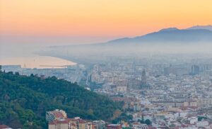aerial photography of city with high-rise buildings viewing mountain under yellow sky during daytime